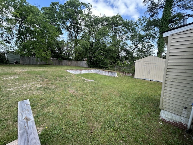 view of yard featuring an outdoor structure, a storage shed, and fence