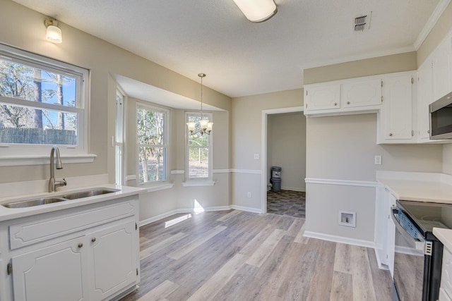 kitchen featuring visible vents, a sink, plenty of natural light, appliances with stainless steel finishes, and white cabinets