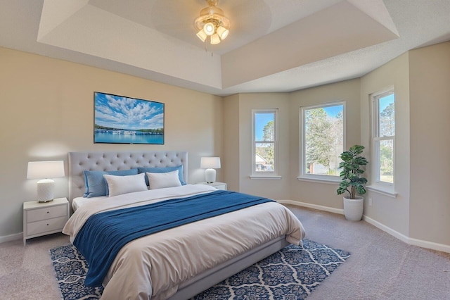 bedroom featuring baseboards, a tray ceiling, and carpet floors