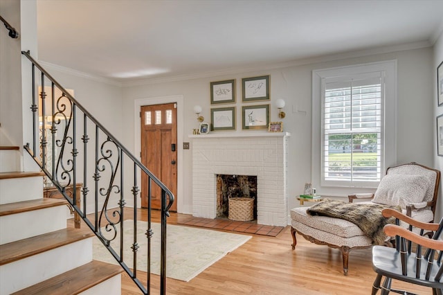 entryway with crown molding, stairway, and wood finished floors