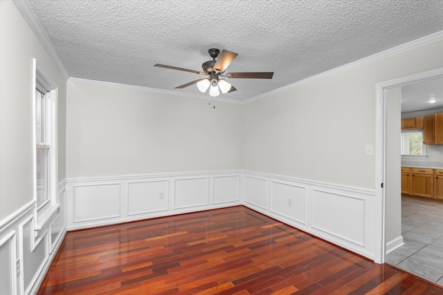 spare room featuring ceiling fan, ornamental molding, dark hardwood / wood-style floors, and a textured ceiling