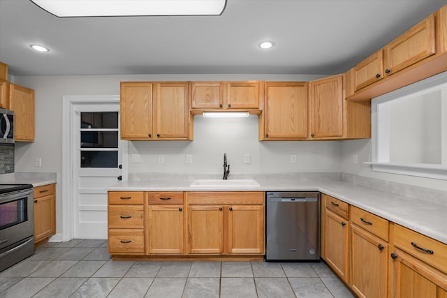 kitchen featuring stainless steel appliances, sink, and light tile patterned floors