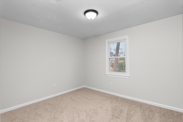 spare room featuring carpet flooring and a textured ceiling