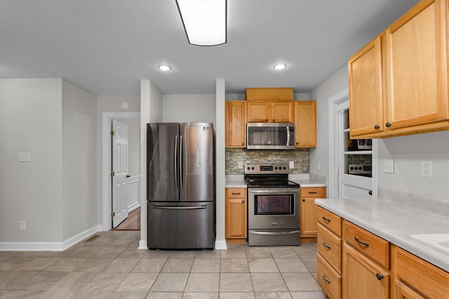 kitchen featuring stainless steel appliances, light tile patterned floors, light brown cabinets, and decorative backsplash