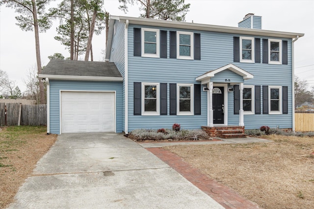 colonial-style house featuring a garage and a front yard