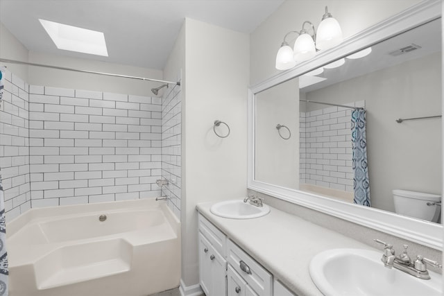 full bathroom featuring vanity, a skylight, shower / bath combination with curtain, and toilet