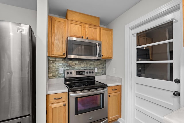 kitchen with stainless steel appliances, backsplash, and light brown cabinetry