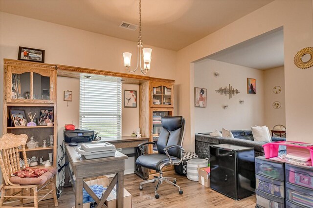 office featuring light wood-type flooring and a notable chandelier