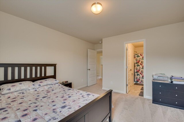 bedroom with light carpet and ensuite bathroom