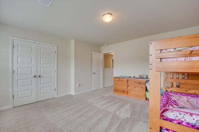 bedroom featuring light colored carpet and a closet