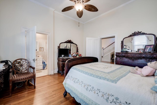 bedroom featuring ceiling fan, hardwood / wood-style floors, crown molding, and connected bathroom