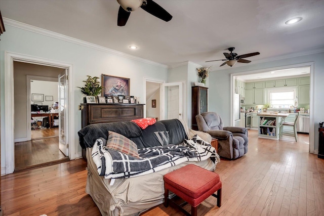 living room with ceiling fan, crown molding, and wood-type flooring