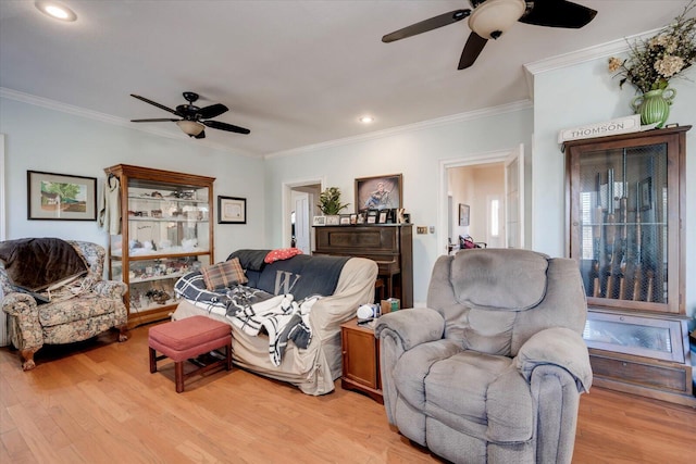 living room featuring ornamental molding, ceiling fan, and light hardwood / wood-style floors