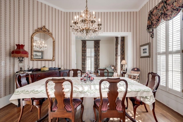 dining room featuring hardwood / wood-style flooring, an inviting chandelier, and crown molding