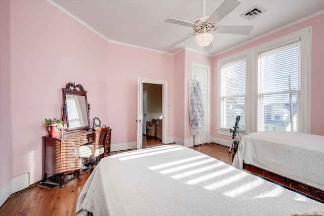 bedroom with ornamental molding, light wood-type flooring, and ceiling fan