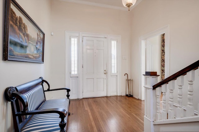 entrance foyer featuring crown molding and light hardwood / wood-style flooring