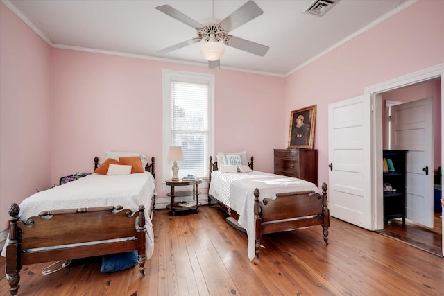 bedroom featuring ceiling fan, crown molding, and hardwood / wood-style flooring