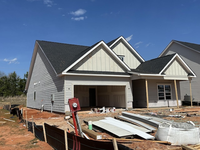 view of front of house featuring a garage, board and batten siding, and roof with shingles