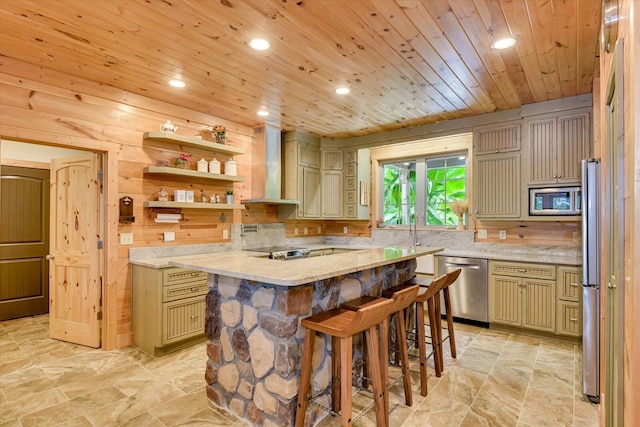 kitchen with wall chimney range hood, a kitchen breakfast bar, wood walls, wood ceiling, and appliances with stainless steel finishes