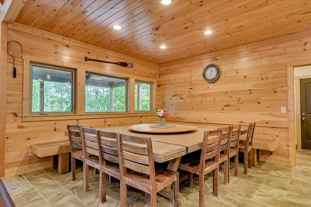 dining space featuring plenty of natural light, wood walls, and wooden ceiling