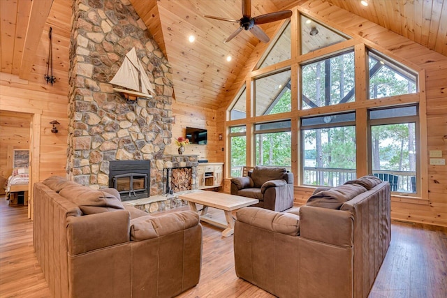 living room featuring wooden ceiling, high vaulted ceiling, wood walls, plenty of natural light, and light hardwood / wood-style floors