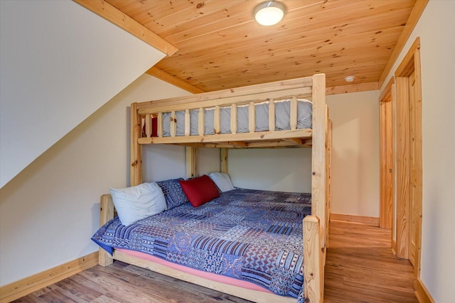 bedroom featuring hardwood / wood-style floors, vaulted ceiling, and wood ceiling