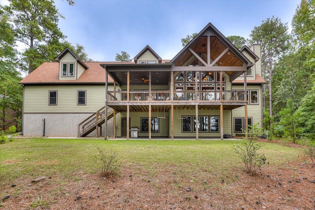 back of house featuring a lawn, ceiling fan, a deck, and a sunroom