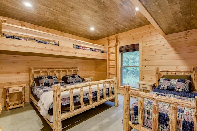 bedroom with concrete floors, wooden ceiling, and wooden walls