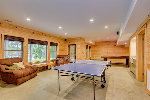 rec room with light colored carpet, pool table, and wood walls