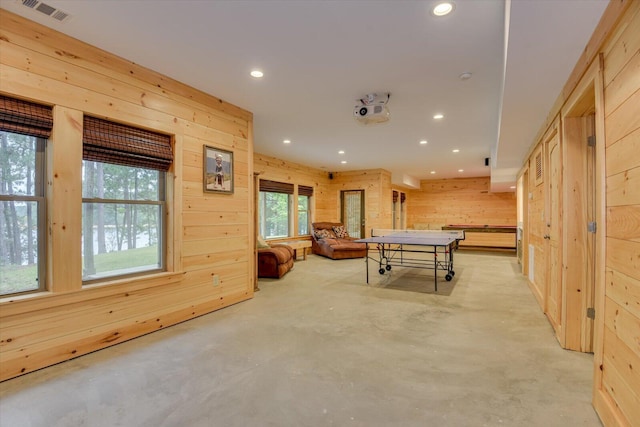 game room featuring a wealth of natural light and wood walls