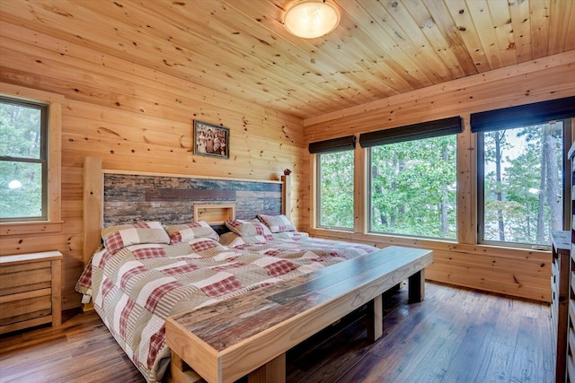 bedroom featuring multiple windows, wood walls, hardwood / wood-style floors, and wood ceiling