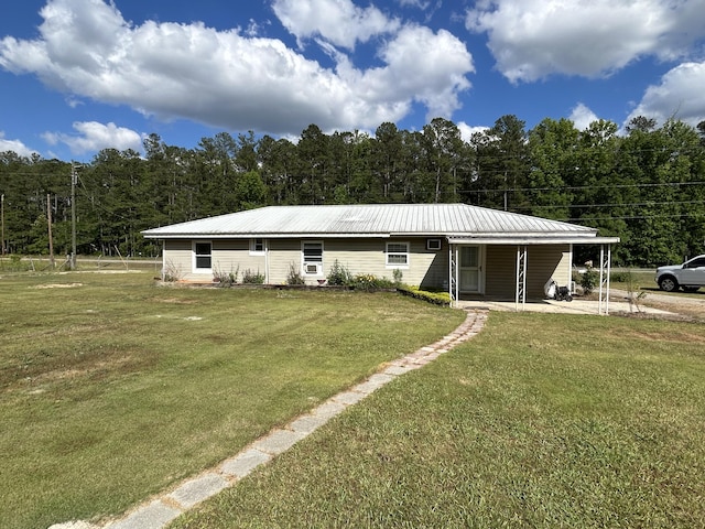 view of front of house featuring a front yard, a view of trees, and metal roof
