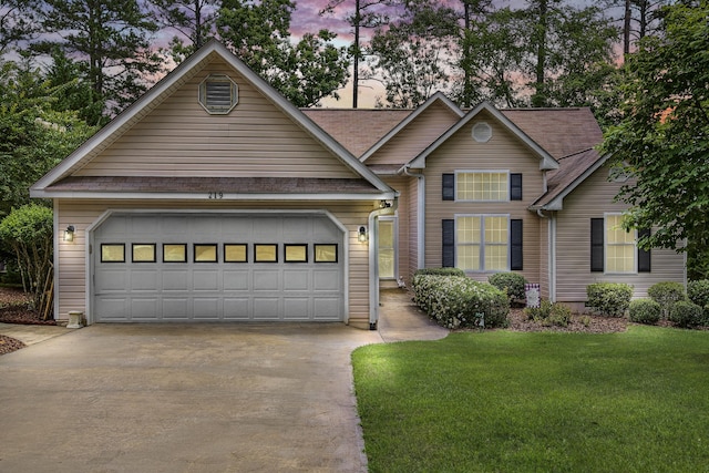 traditional-style home featuring a front yard, driveway, and an attached garage