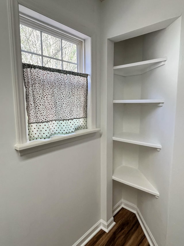 interior details with built in features, baseboards, and wood finished floors