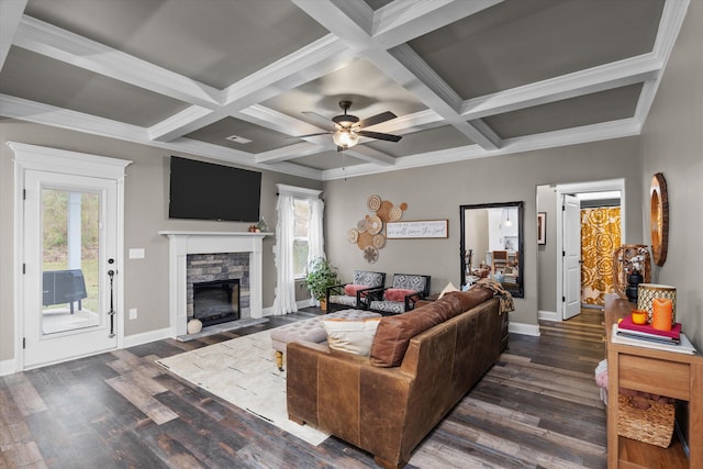 living room with dark wood finished floors, a wealth of natural light, and a stone fireplace