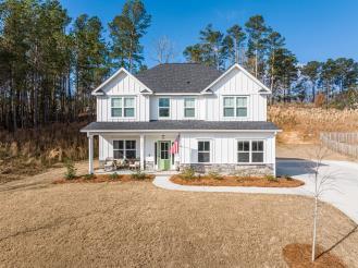 view of front of property featuring board and batten siding, a porch, and driveway