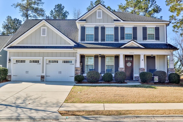 craftsman house featuring covered porch, a garage, and a front lawn