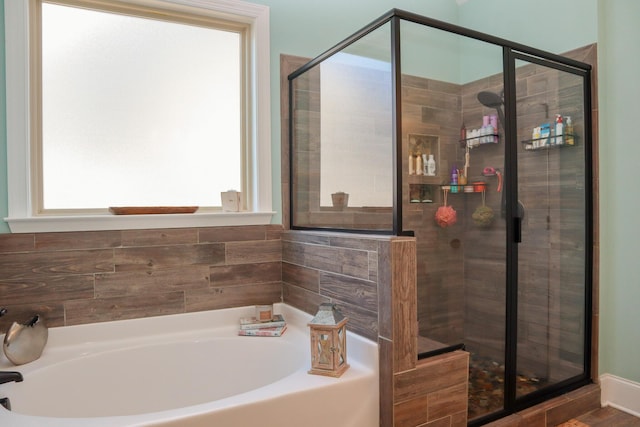 bathroom featuring independent shower and bath and a wealth of natural light