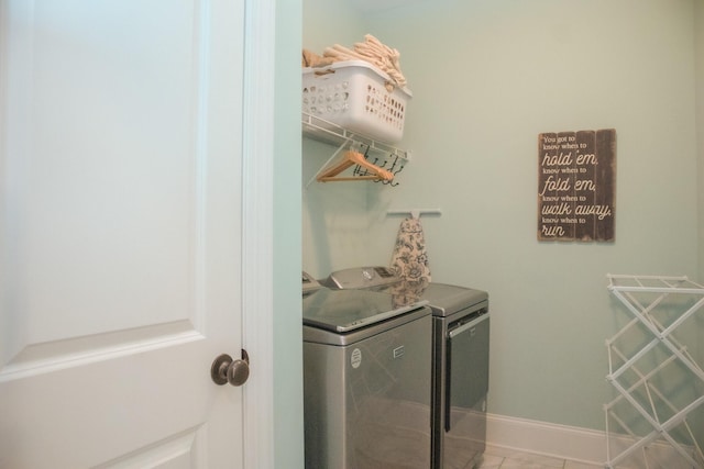 laundry area with independent washer and dryer and tile patterned flooring