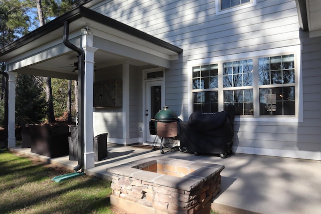 view of patio / terrace with ceiling fan and a fire pit