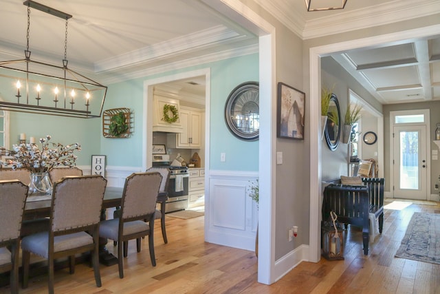 dining space with crown molding and light hardwood / wood-style flooring