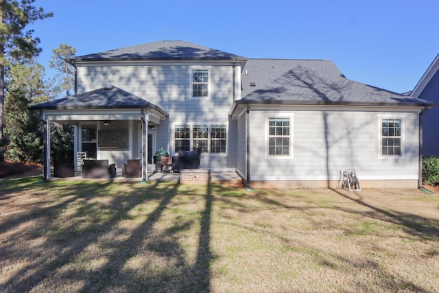 rear view of house featuring a yard and a patio