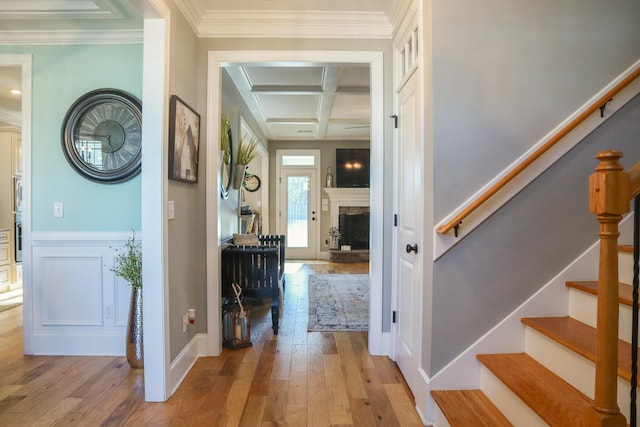 corridor featuring beam ceiling, light wood-type flooring, crown molding, and coffered ceiling