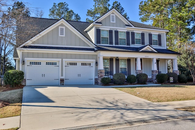 craftsman house featuring a front yard, covered porch, and a garage