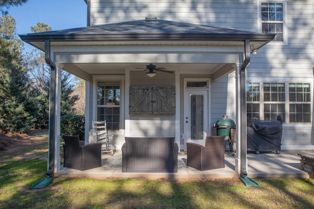 view of exterior entry featuring ceiling fan and a patio