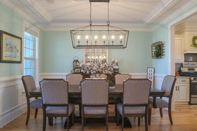 dining space featuring an inviting chandelier, crown molding, and light hardwood / wood-style floors