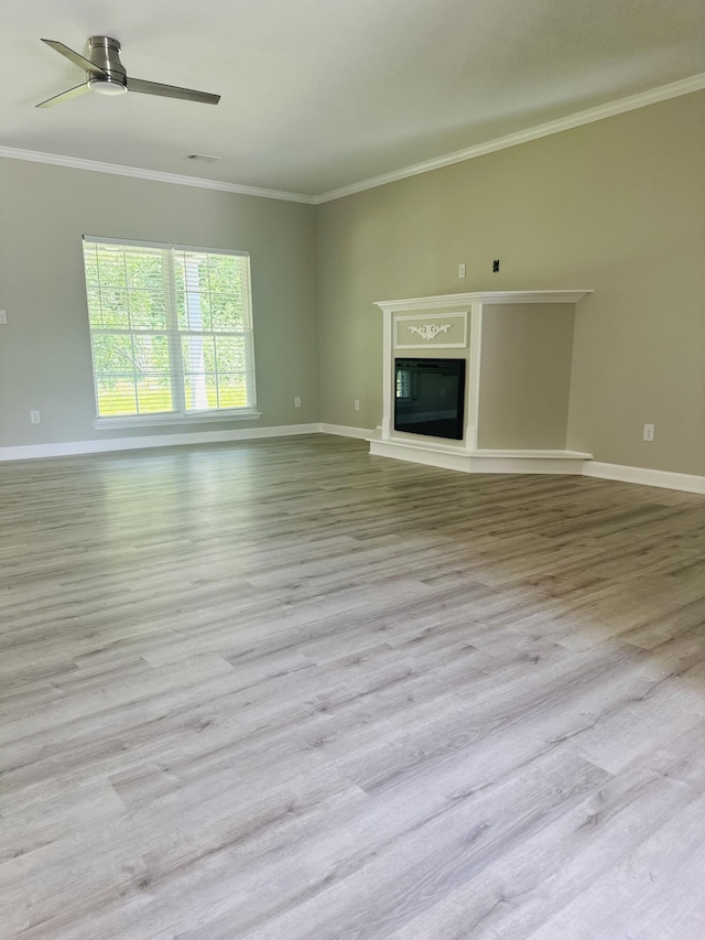 unfurnished living room with crown molding and light wood-type flooring