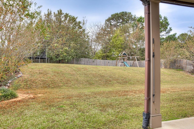 view of yard featuring a trampoline and a playground