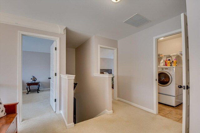 corridor with light colored carpet and washer / dryer