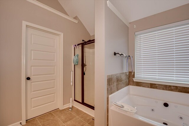 bathroom featuring tile patterned flooring, separate shower and tub, and vaulted ceiling